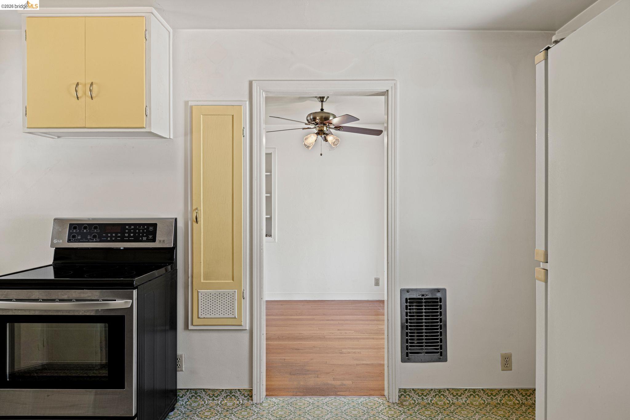 7501 Heather Road Fair Oaks, CA 95628 - Photo 27 of 82 Stainless steel range, yellow upper cabinetry, built-in yellow storage cabinet, patterned floor tile, and a wall heater