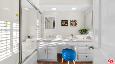 a bathroom with a granite countertop sink a mirror and a bathtub