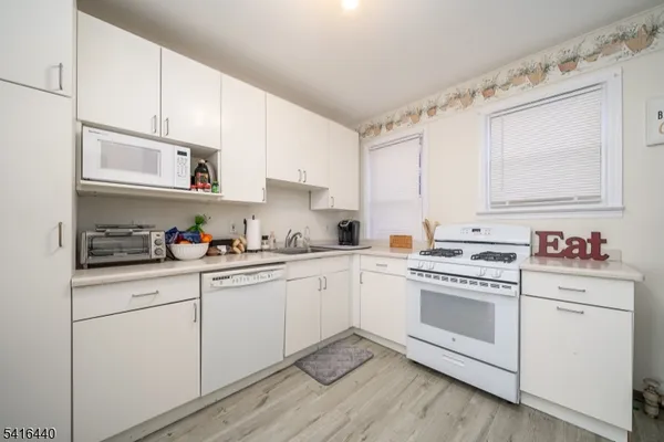 a kitchen with cabinets stainless steel appliances and a sink