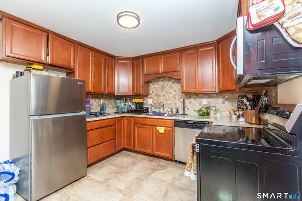a kitchen with granite countertop stainless steel appliances and wooden cabinets