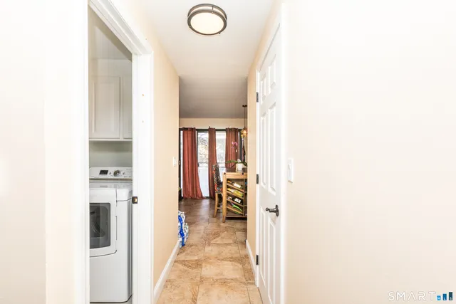 a view of a hallway with wooden floor and living room