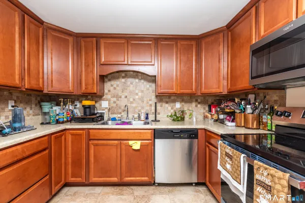 a kitchen with stainless steel appliances granite countertop a sink a stove and cabinets