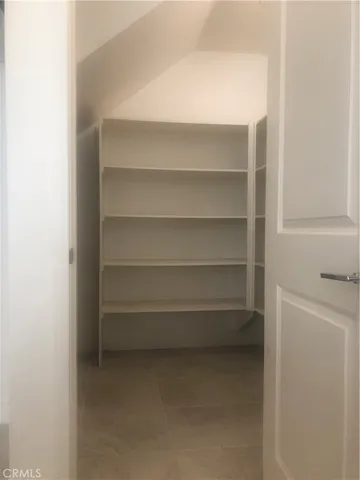 a view of a swimming pool with a bench and trees in front of main door