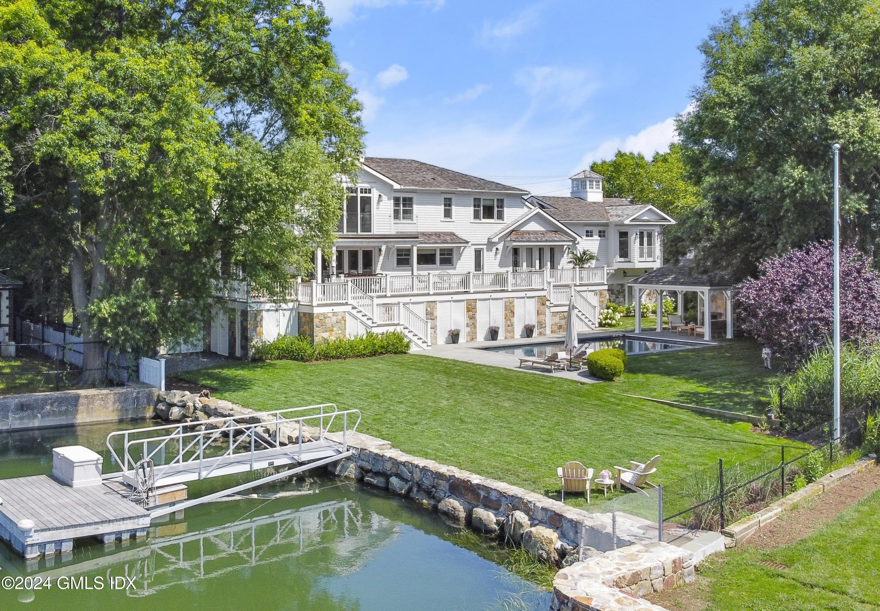 195 Shore Road Old Greenwich, CT 06870 - Photo 1 of 39 a view of a house with backyard sitting area and pool