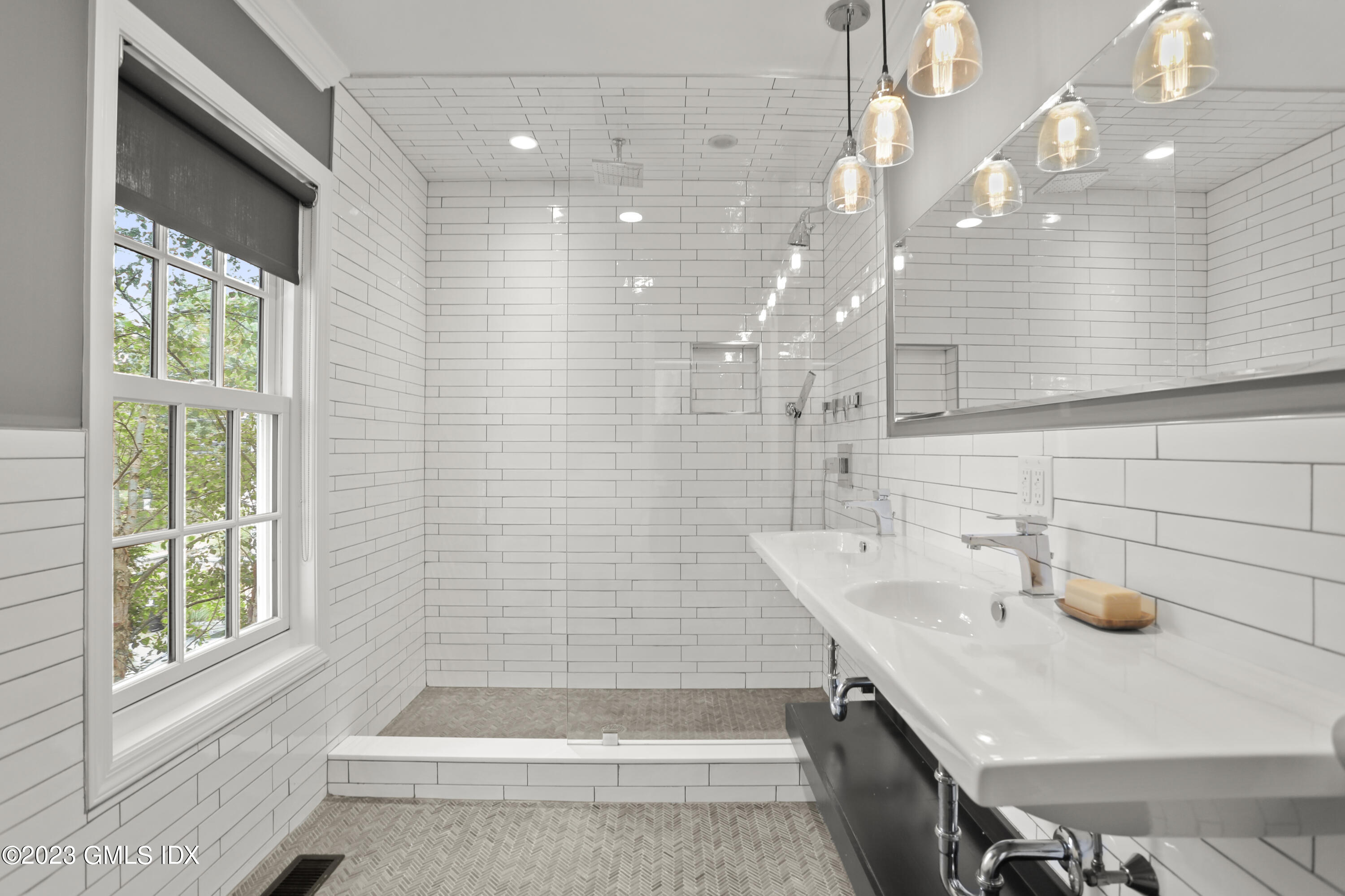 195 Shore Road Old Greenwich, CT 06870 - Photo 19 of 39 a bathroom with a sink a bathtub and shower