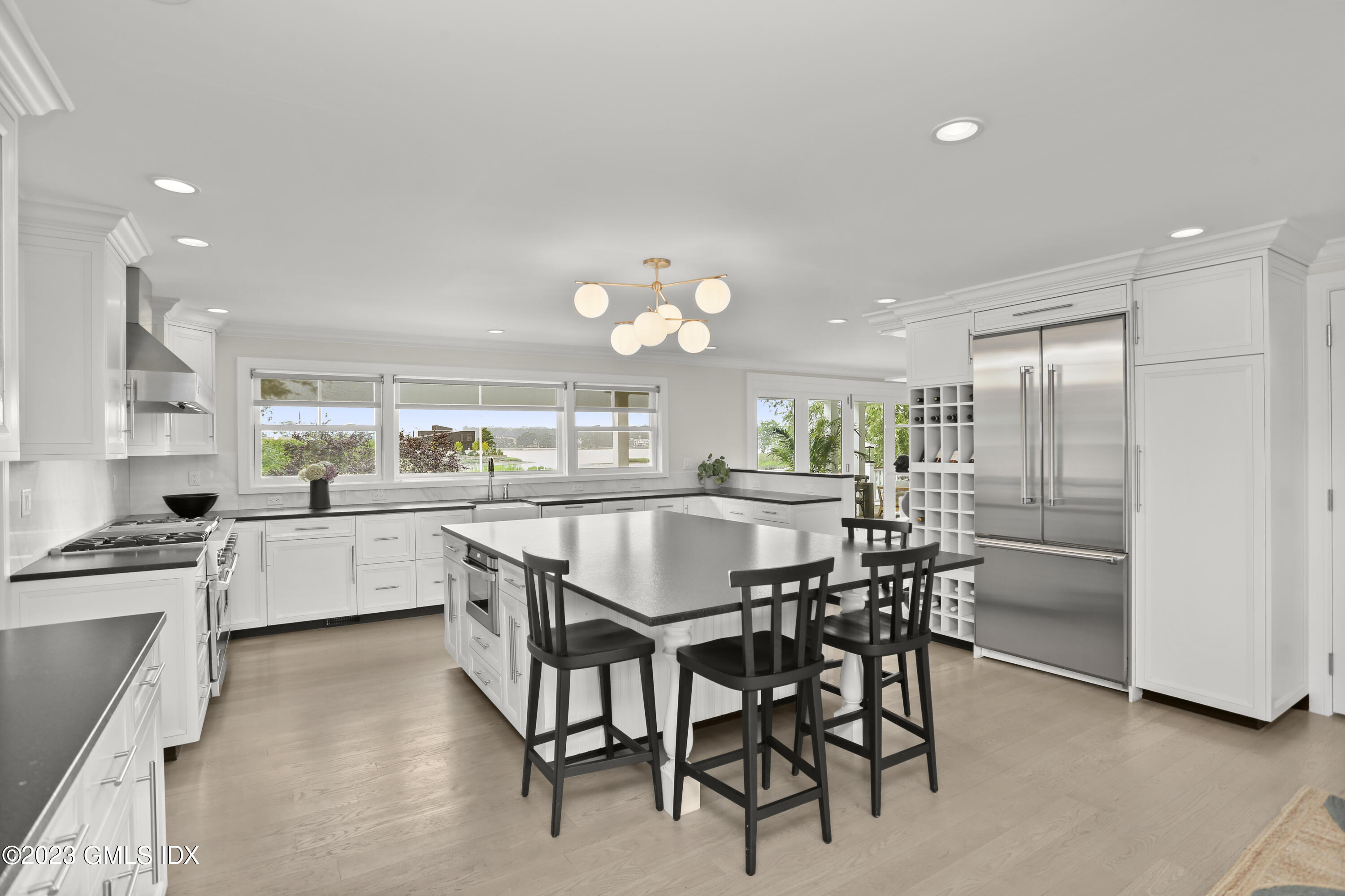 195 Shore Road Old Greenwich, CT 06870 - Photo 9 of 39 a kitchen with kitchen island a dining table chairs stainless steel appliances and cabinets