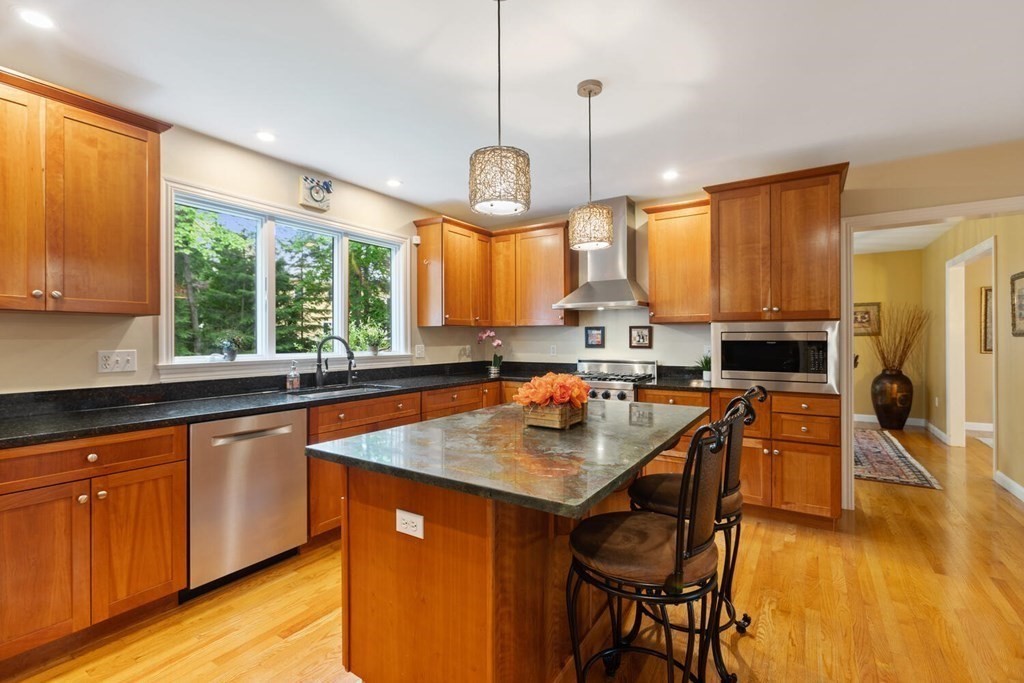 34 Woodcliffe Road Lexington, MA 02421 - Photo 13 of 34 a kitchen with stainless steel appliances granite countertop wooden floors a stove a sink a dining table and chairs