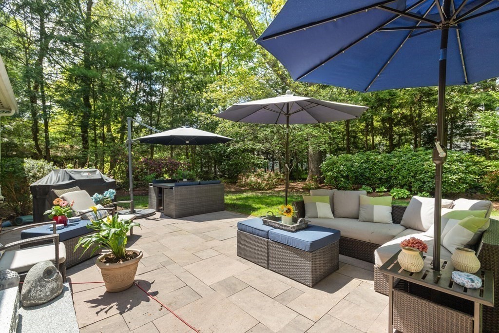 34 Woodcliffe Road Lexington, MA 02421 - Photo 33 of 34 a patio with tables and chairs under an umbrella