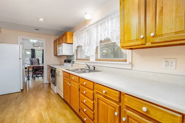 a large kitchen with stainless steel appliances a sink window and cabinets