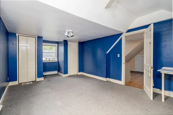 a view of an empty room with closet and window