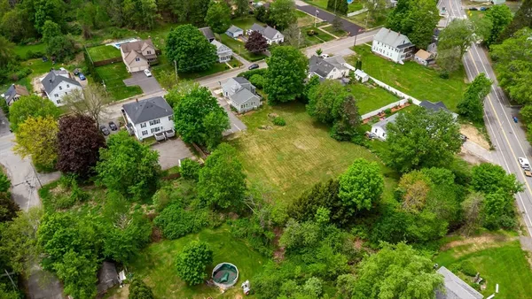 an aerial view of residential house with outdoor space and trees all around