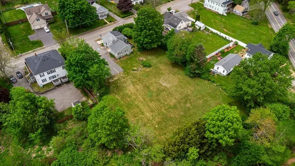 an aerial view of residential house with outdoor space and trees all around