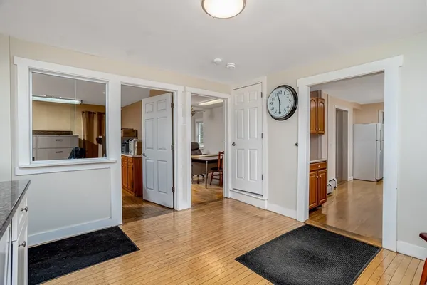 a view of a hallway with wooden floor and a living room