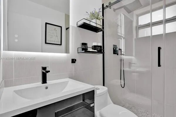a bathroom with a sink a toilet and shower