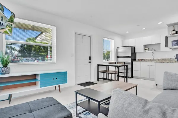 a kitchen with stainless steel appliances kitchen island granite countertop a refrigerator and microwave