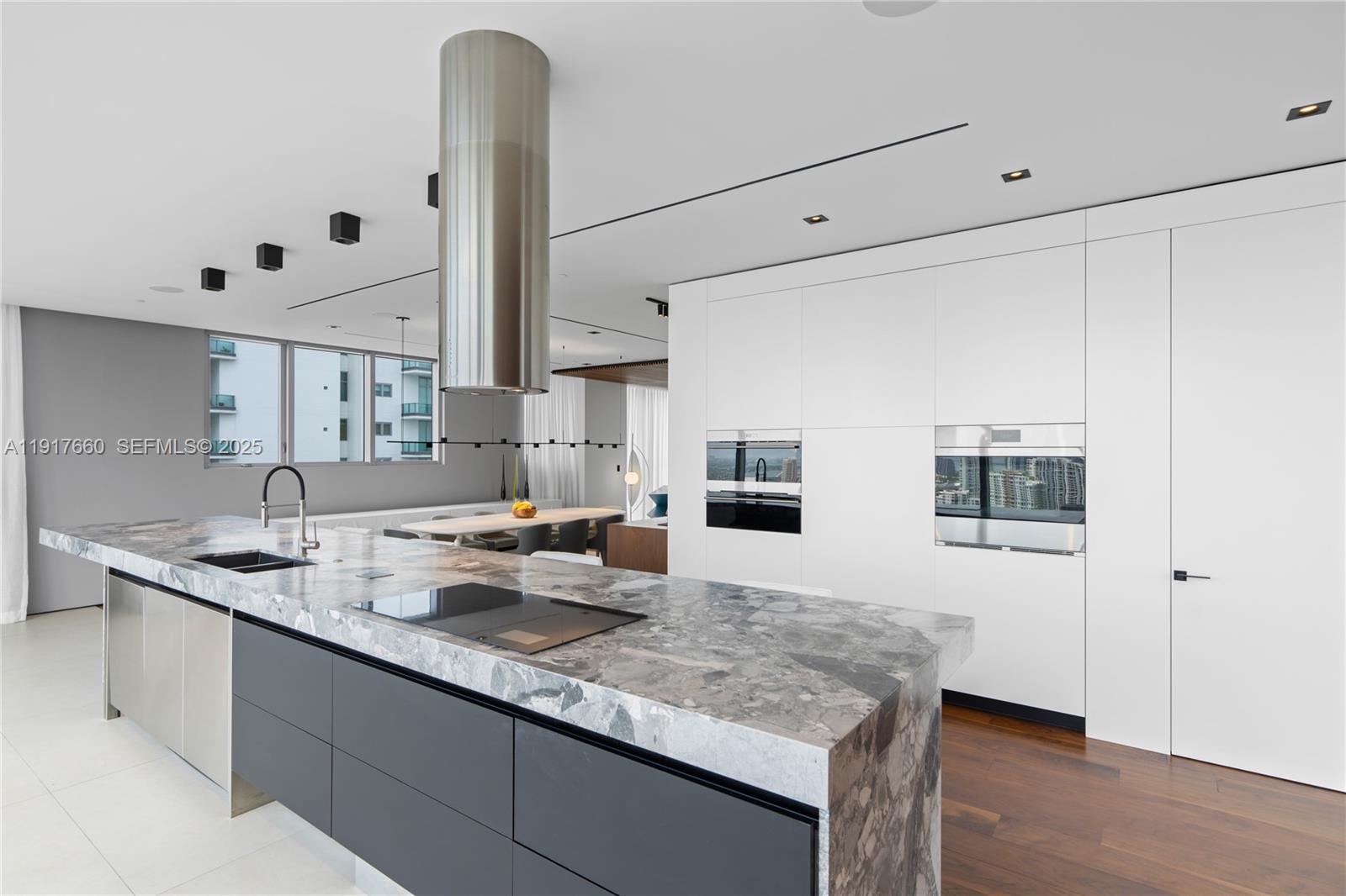 1300 Brickell Bay Drive, Unit 4401 Miami, FL 33131 - Photo 23 of 34 a kitchen with granite countertop white cabinets and refrigerator