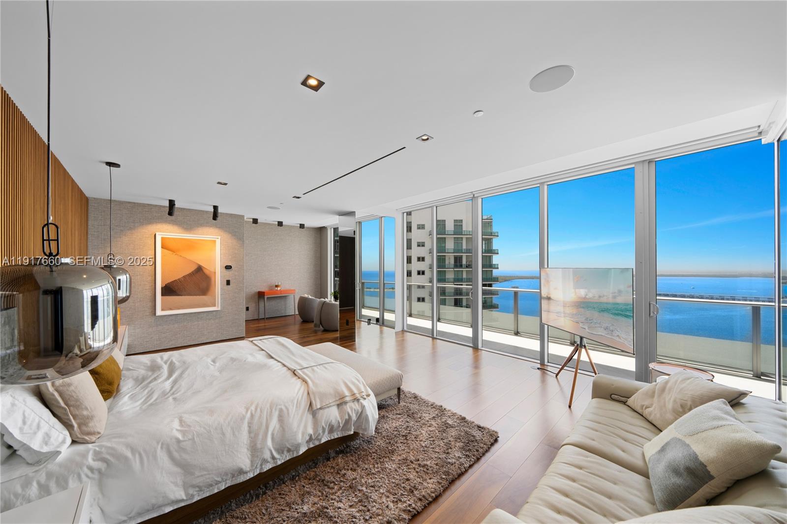 1300 Brickell Bay Drive, Unit 4401 Miami, FL 33131 - Photo 31 of 34 a bedroom with a large bed a couch and a chandelier