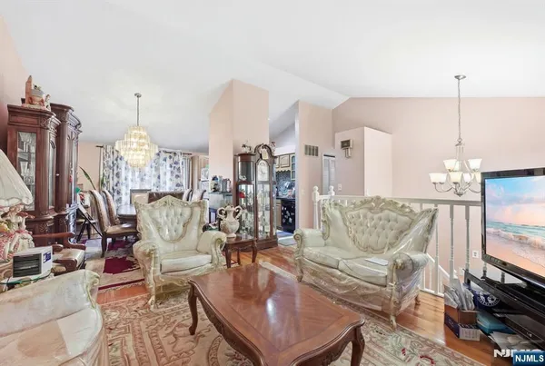a living room with furniture a fireplace and a chandelier