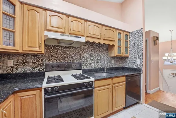 a kitchen with stainless steel appliances granite countertop a stove and a sink