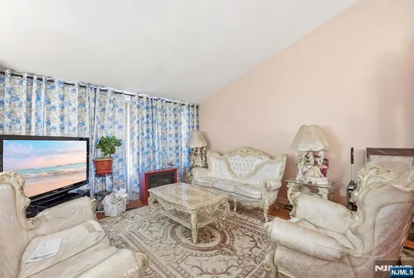 a living room with furniture a flat screen tv and a floor to ceiling window