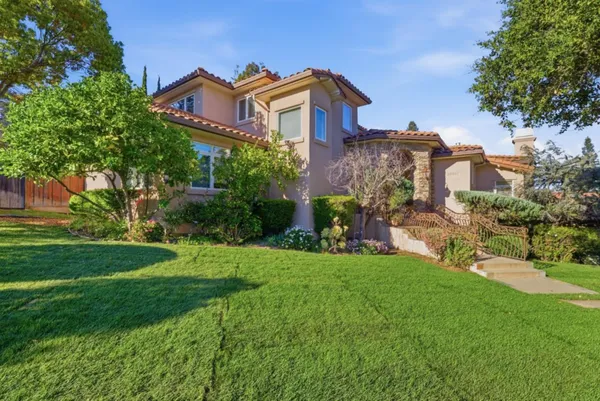 a front view of a house with a yard and trees