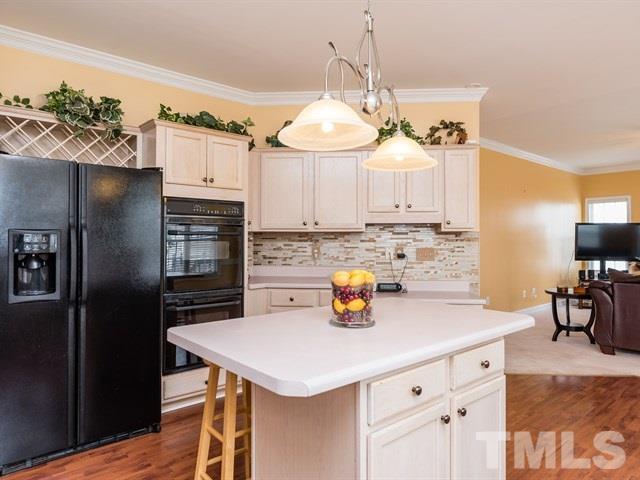 3553 Dewing Drive Raleigh, NC 27616 - Photo 12 of 25 a kitchen with a sink a kitchen island and stainless steel appliances