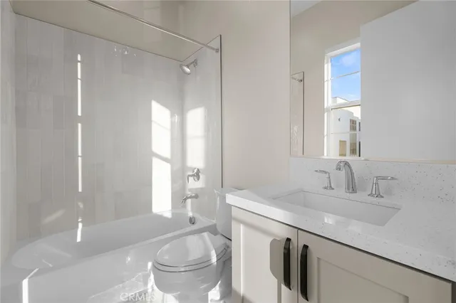 a bathroom with a sink a toilet and a large mirror