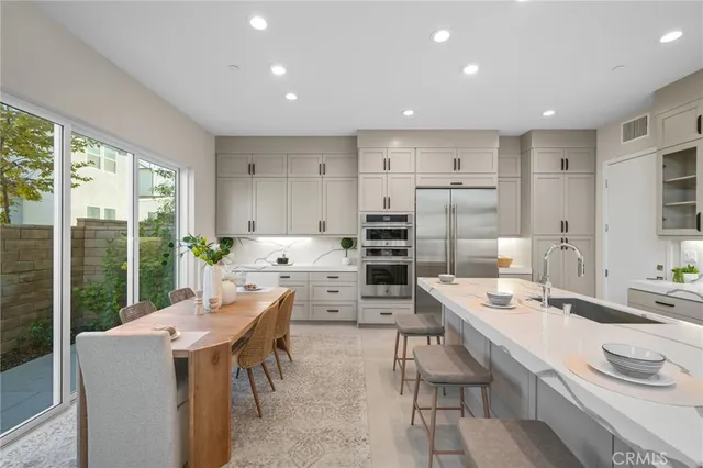 a large kitchen with kitchen island a large window in it