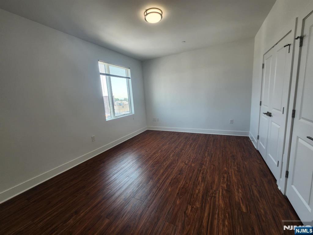 77 Ridge, Unit 306 North Arlington, NJ 07031 - Photo 13 of 23 an empty room with wooden floor and windows