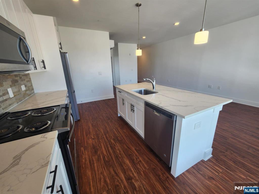 77 Ridge, Unit 306 North Arlington, NJ 07031 - Photo 7 of 23 a kitchen with a sink a wooden floor and a refrigerator