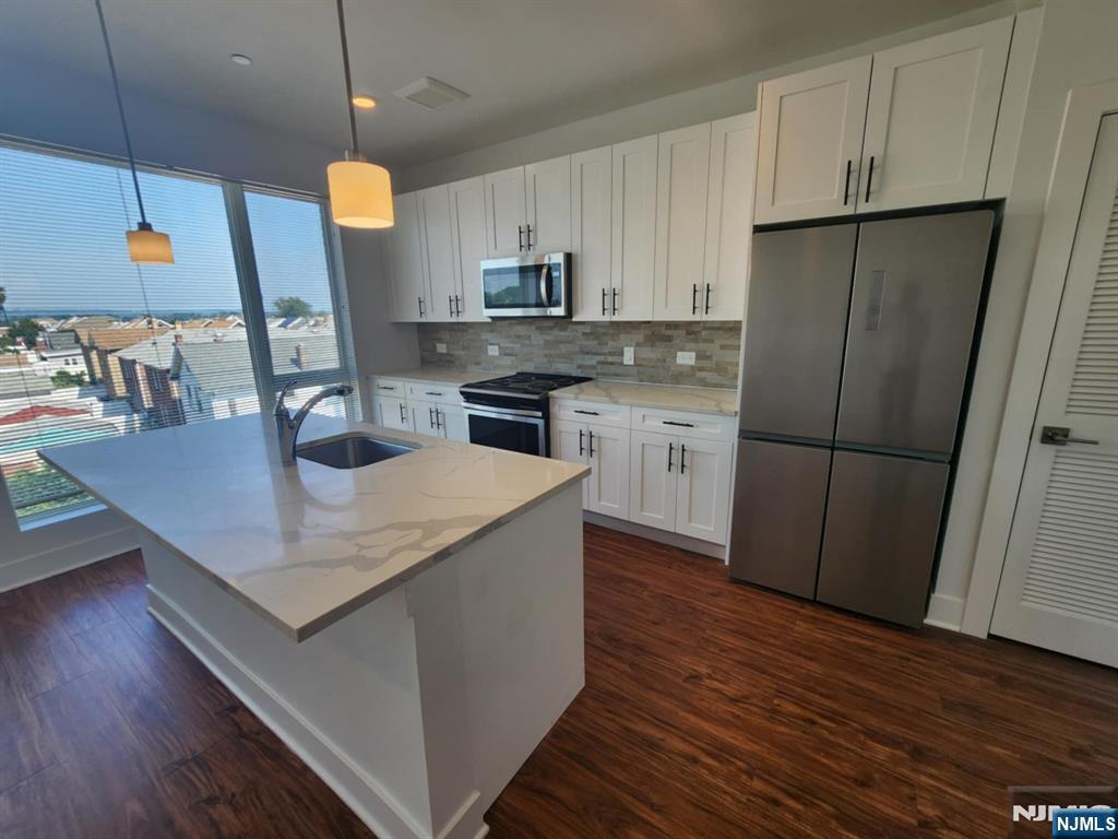 77 Ridge, Unit 306 North Arlington, NJ 07031 - Photo 9 of 23 a kitchen with a sink a refrigerator and wooden floor