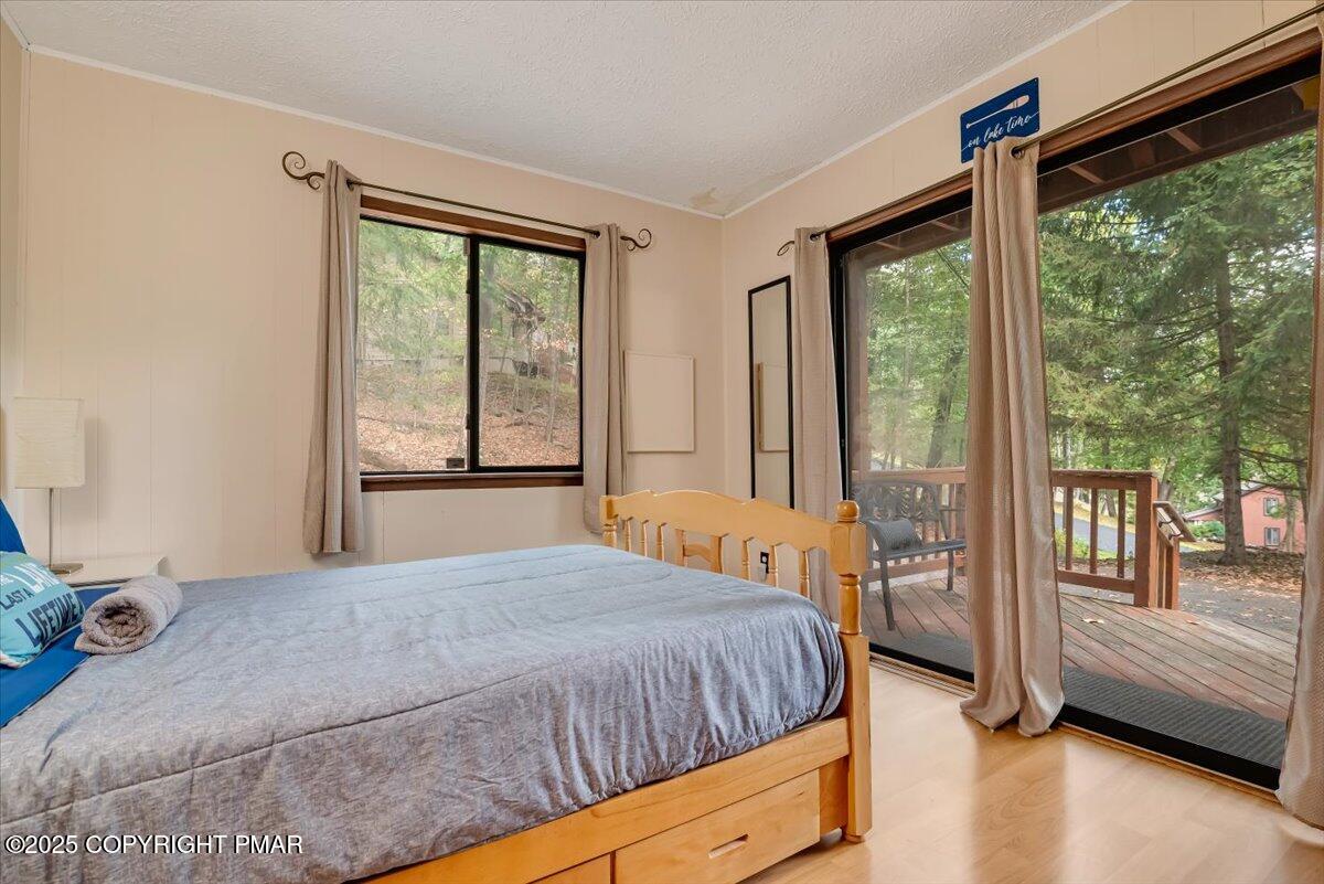 2108 Scarborough Way Bushkill, PA 18324 - Photo 42 of 105 a bedroom with a balcony a bed and a large window with outer view