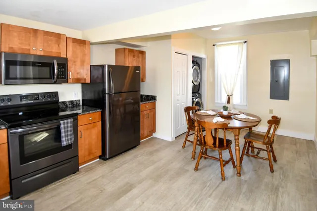 a kitchen with stainless steel appliances wooden floor dining table and chairs