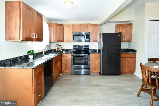 a kitchen with stainless steel appliances granite countertop a refrigerator stove and microwave