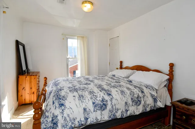 a bed sitting in a bedroom next to a window