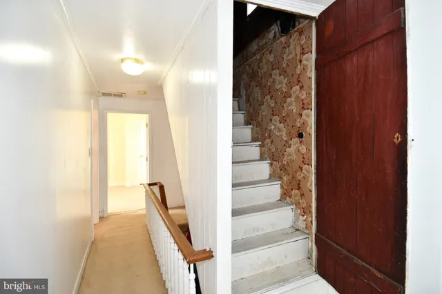 a view of a hallway with wooden floor and staircase