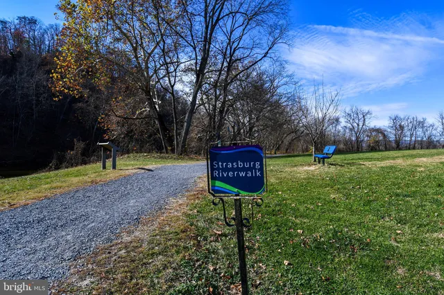 a sign board with tall trees in the background