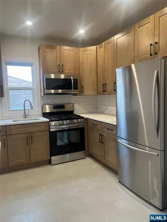 a kitchen with granite countertop a refrigerator stove and sink