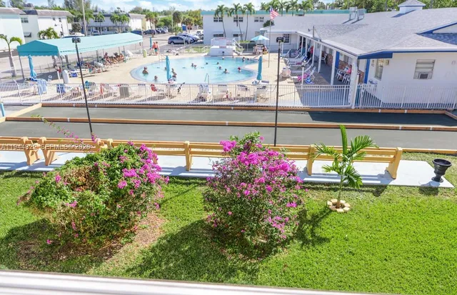 a view of a swimming pool with a flower garden
