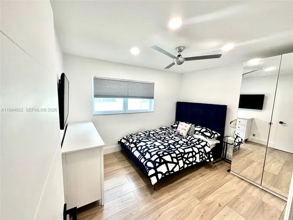 a bedroom with a bed window and a flat screen tv