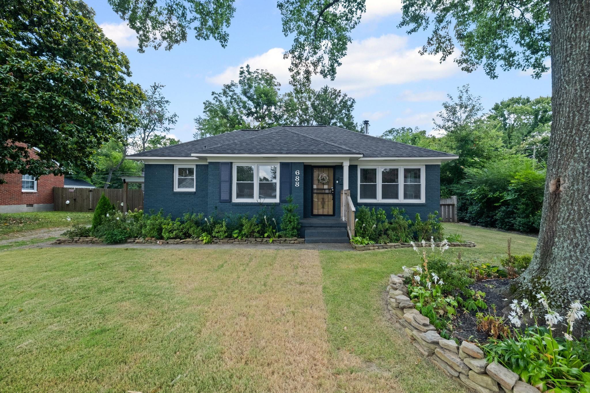 View of front of home with a shingled roof and brick siding