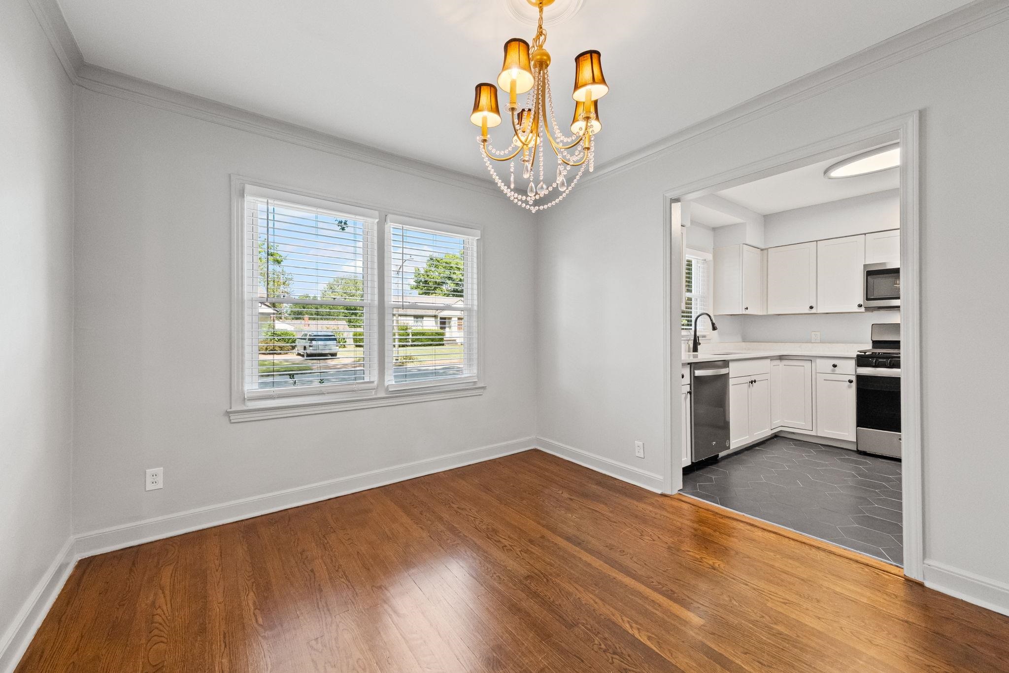 688 Berry Road Memphis, TN 38117 - Photo 4 of 16 Unfurnished dining area featuring ornamental molding, a chandelier, and dark wood-style floors