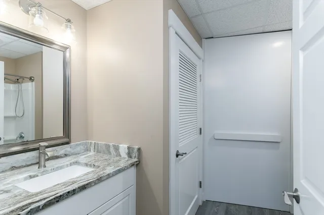 a bathroom with a granite countertop sink and a mirror