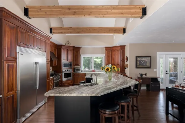 a kitchen with stainless steel appliances granite countertop a refrigerator a stove a sink dishwasher with a dining table and chairs