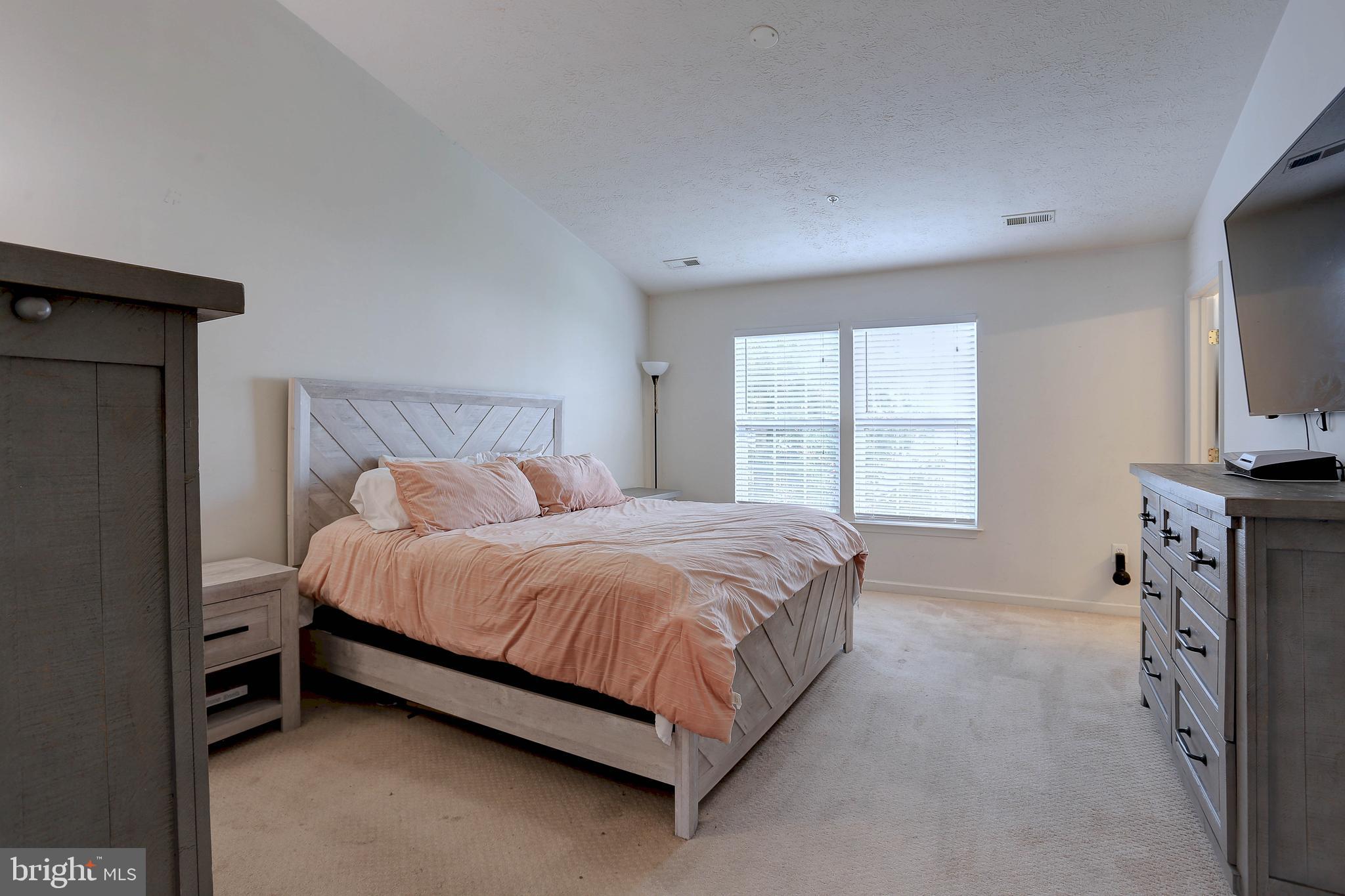 819 Lowe Road Middle River, MD 21220 - Photo 14 of 26 a spacious bedroom with a bed and a flat screen tv