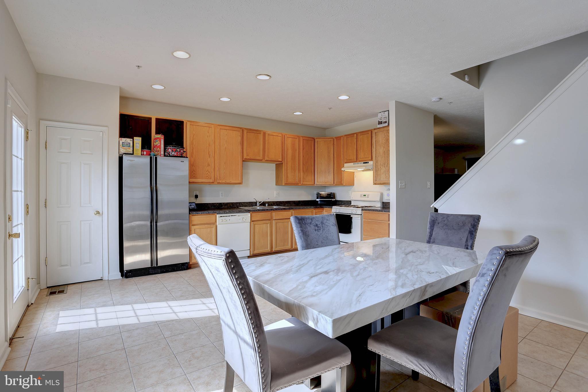 819 Lowe Road Middle River, MD 21220 - Photo 10 of 26 a kitchen with stainless steel appliances granite countertop a dining table chairs and refrigerator