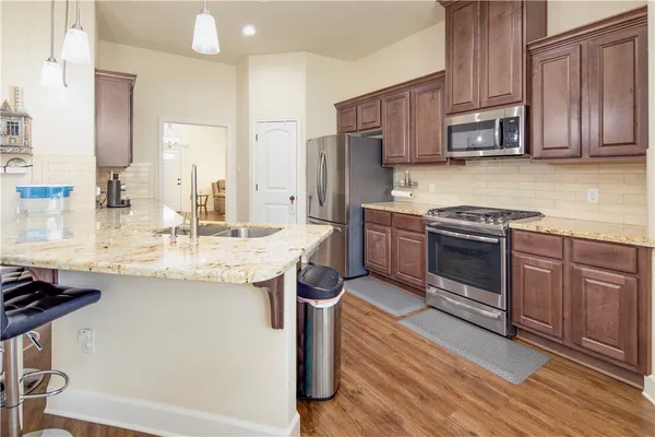 a kitchen with stainless steel appliances granite countertop wooden cabinets a stove top oven a sink and dishwasher