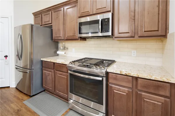 a kitchen with granite countertop wooden cabinets and stainless steel appliances