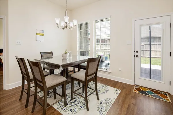 a dining room with furniture a chandelier and wooden floor