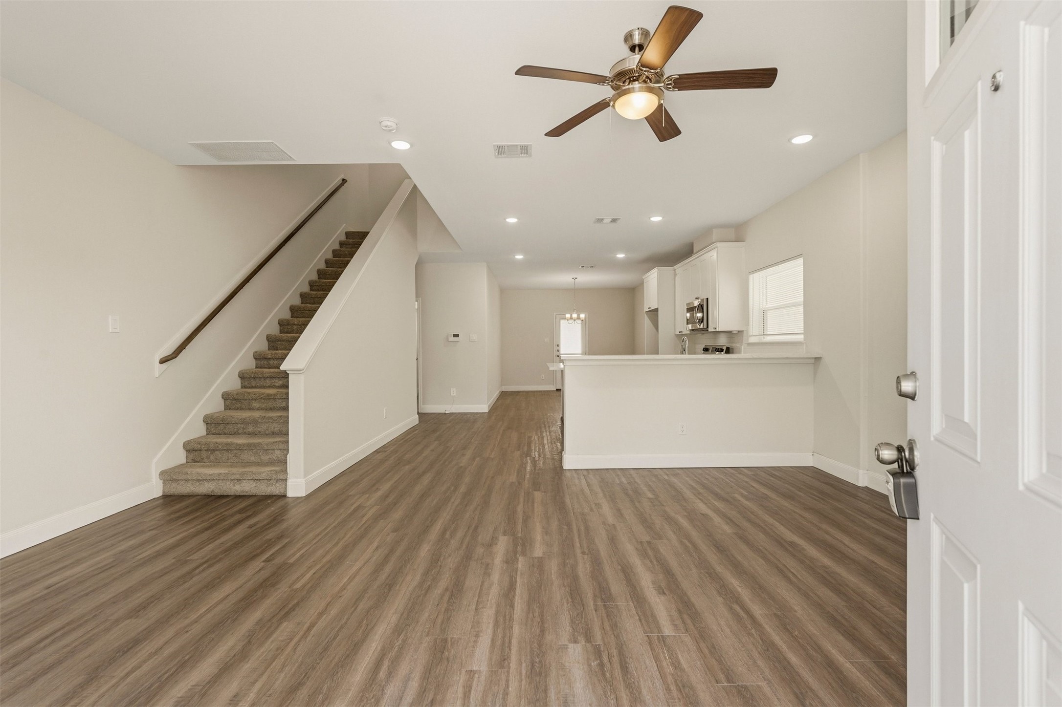 2218 Bringhurst Street, Unit B Houston, TX 77026 - Photo 3 of 25 a view of a livingroom with wooden floor a ceiling fan and kitchen space